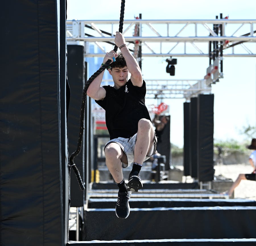 Male athlete swining on a rope