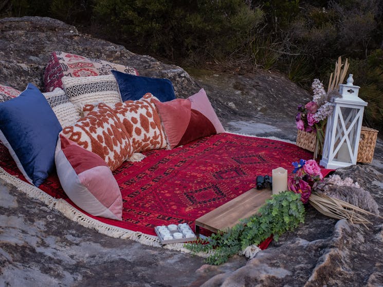 A blanket and pillows on a rock