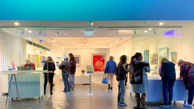 entrance of gallery space with people & blue lighting