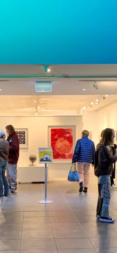entrance of gallery space with people & blue lighting