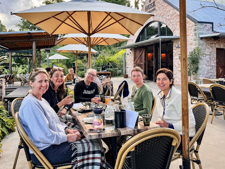 Group of women around a table at Husk Farm Distillery after completing their e bike tour