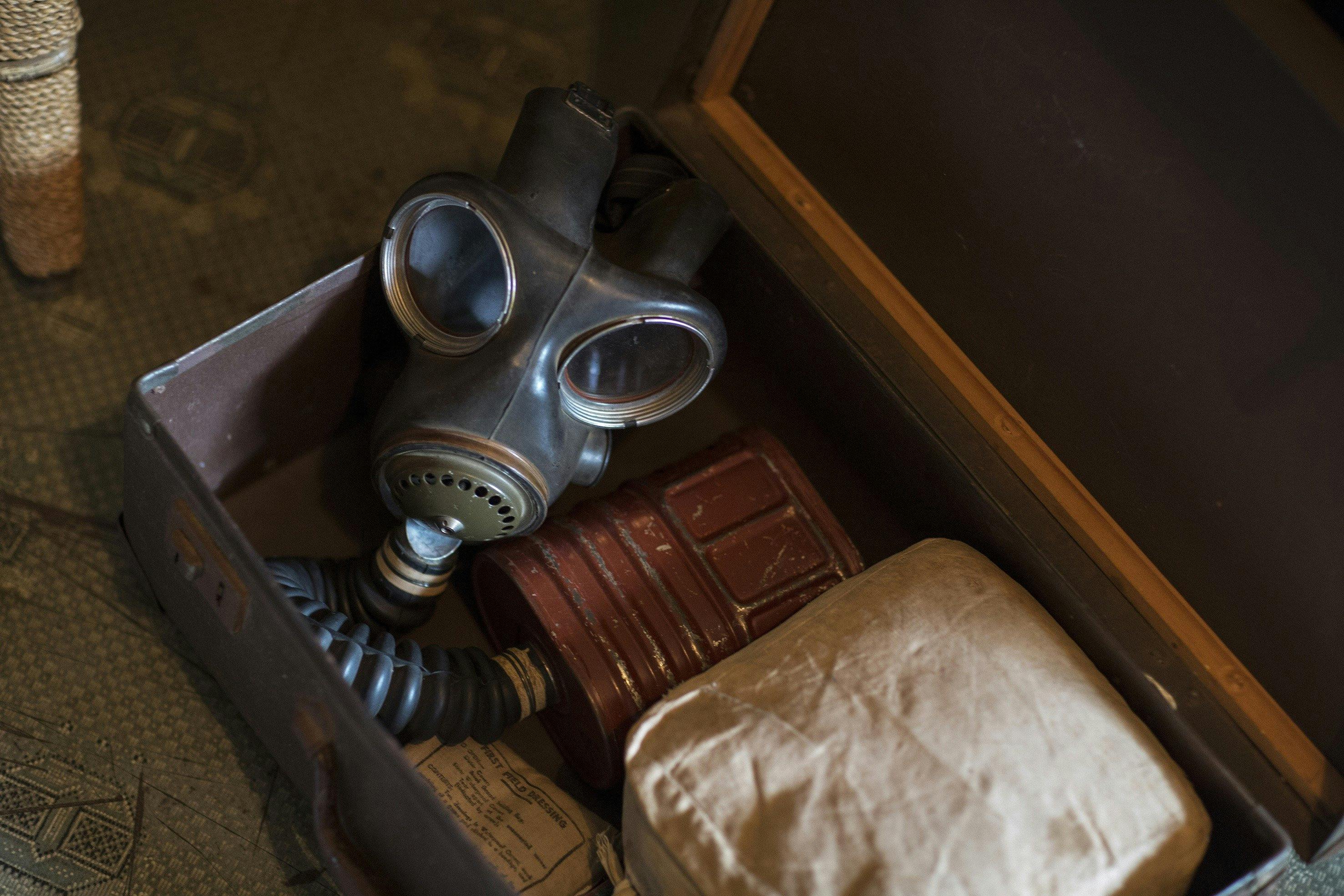 An open suitcase containing a WWII gas mask
