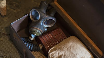 An open suitcase containing a WWII gas mask