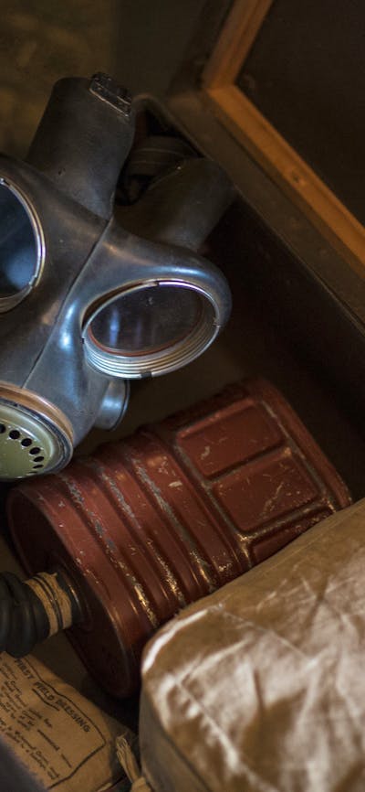 An open suitcase containing a WWII gas mask
