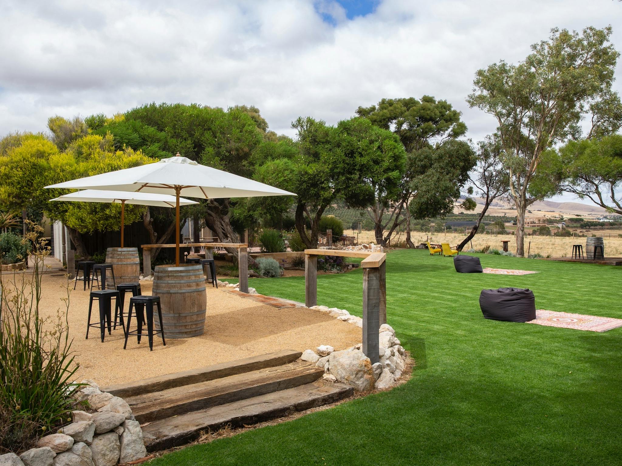 Outdoor area, including wine barrels, umbrellas, stools, rugs and beanbags