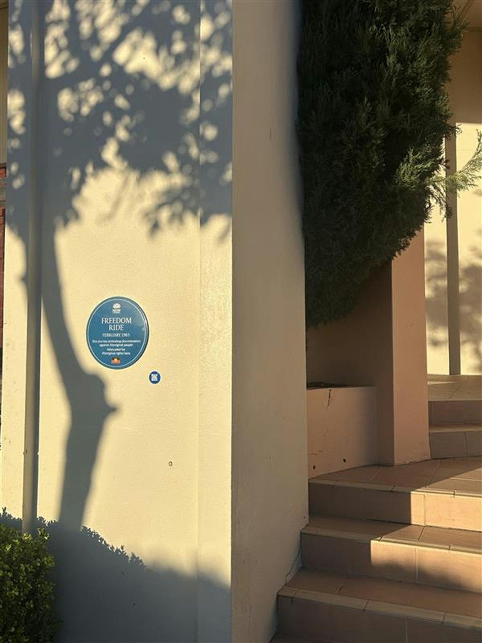 Blue plaque and QR code on rendered cream coloured wall