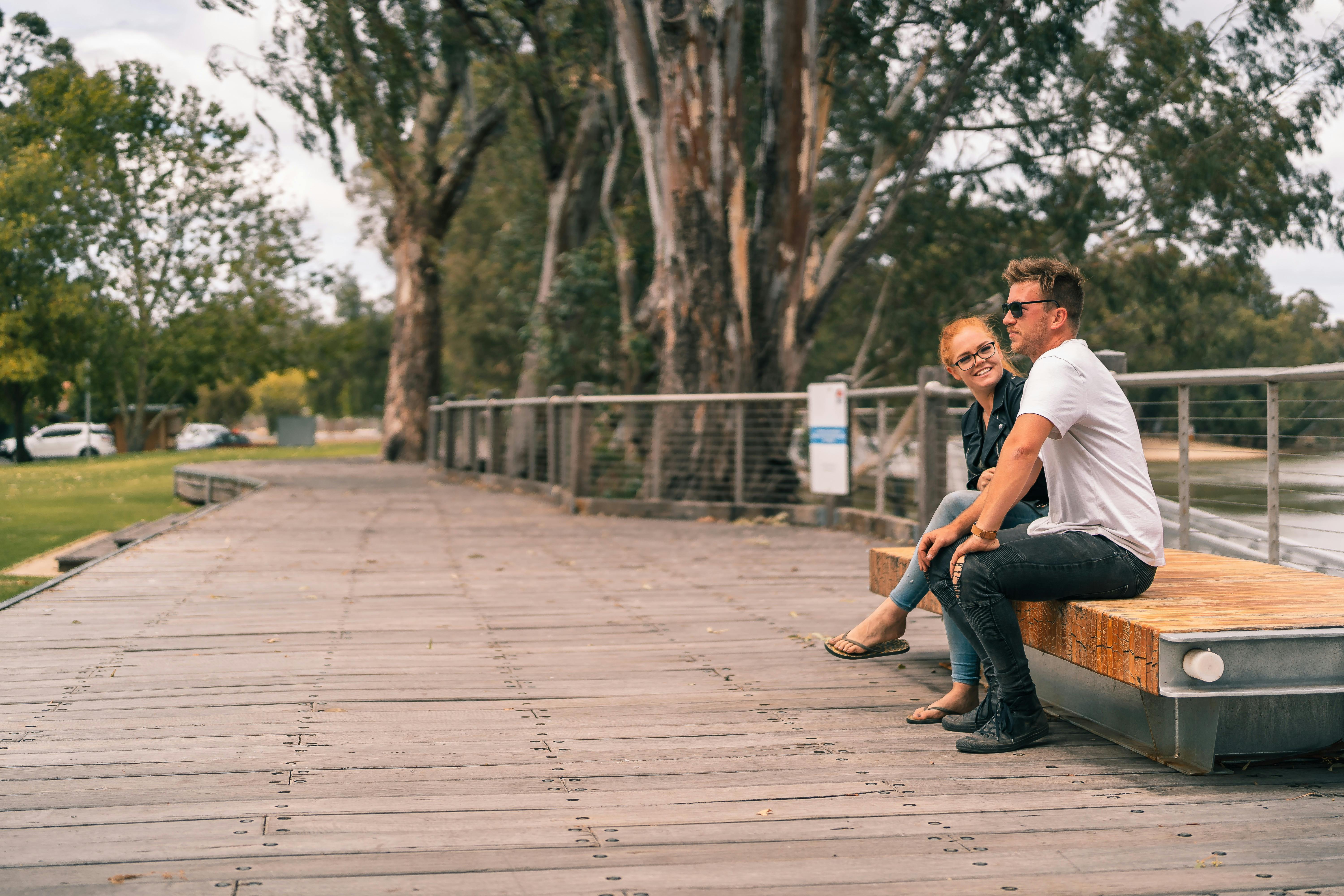 Couple sitting on a wooden boardwalk over looking the river