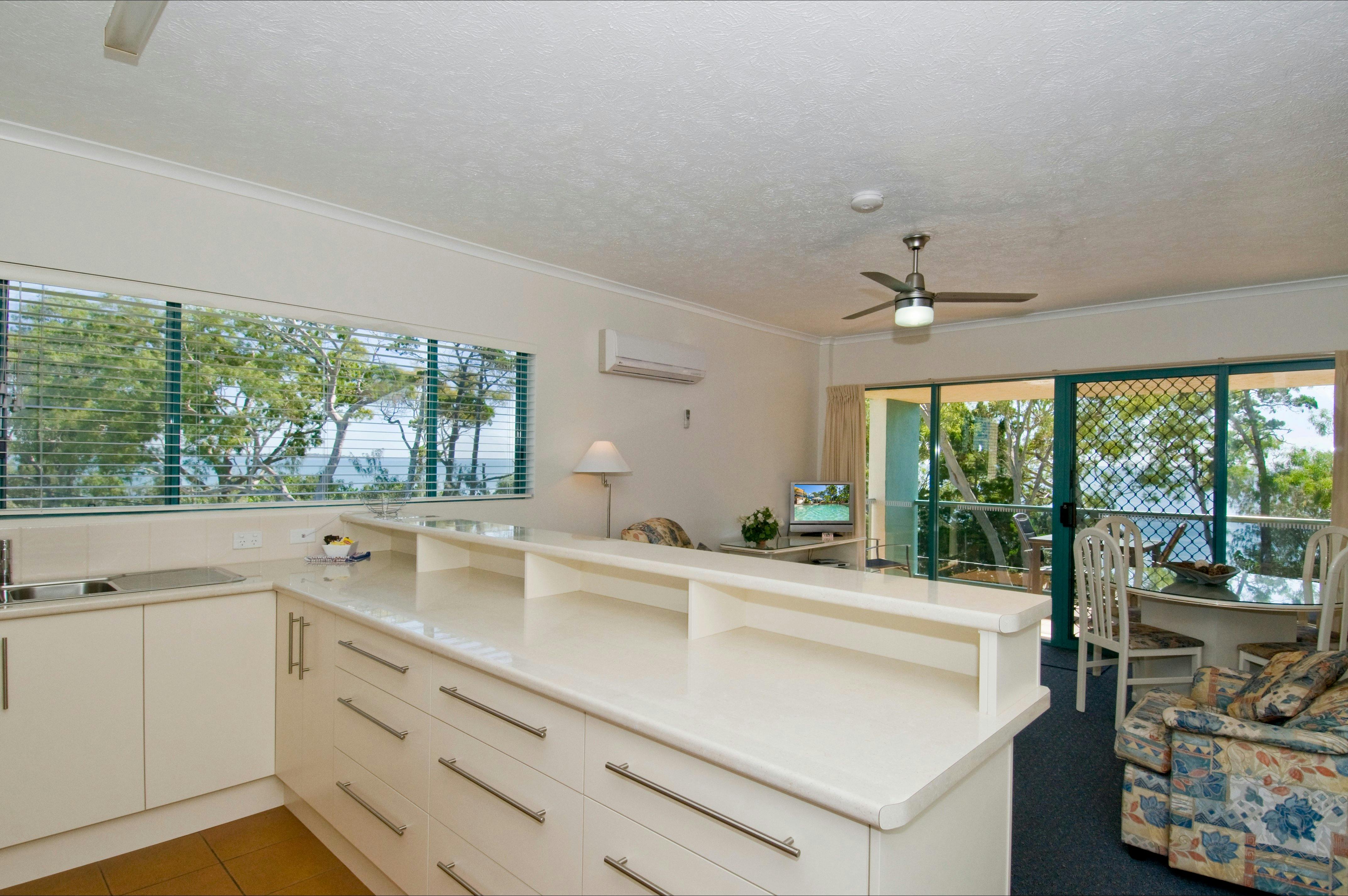 Kitchen with full size refrigerator, oven and cooktop and combined dining & lounge area