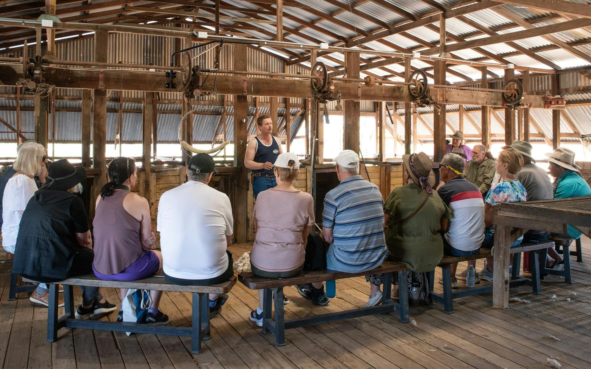 A group of guests listening to a shearer talking