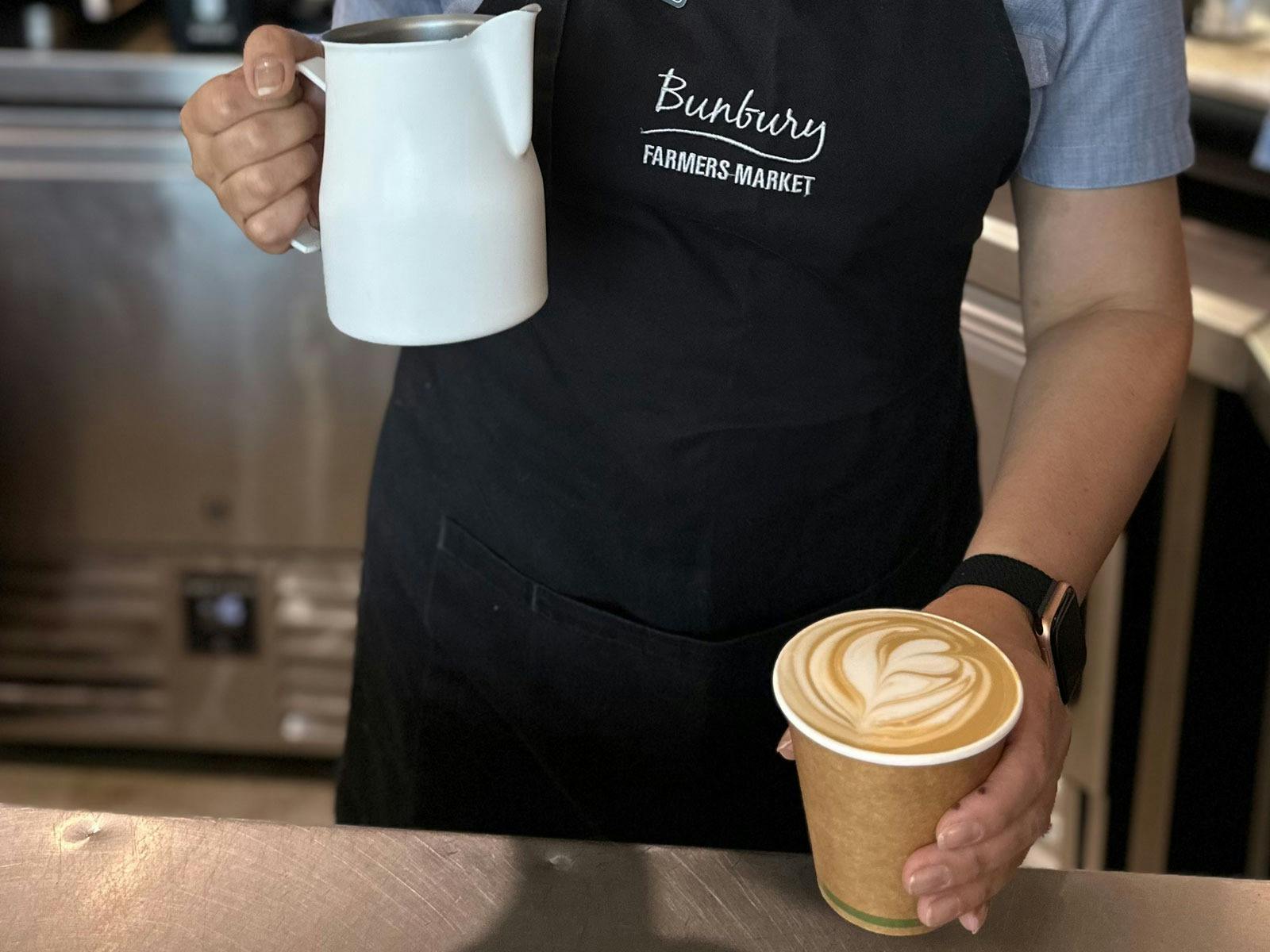 A barista with a coffee at Bunbury Farmers Market
