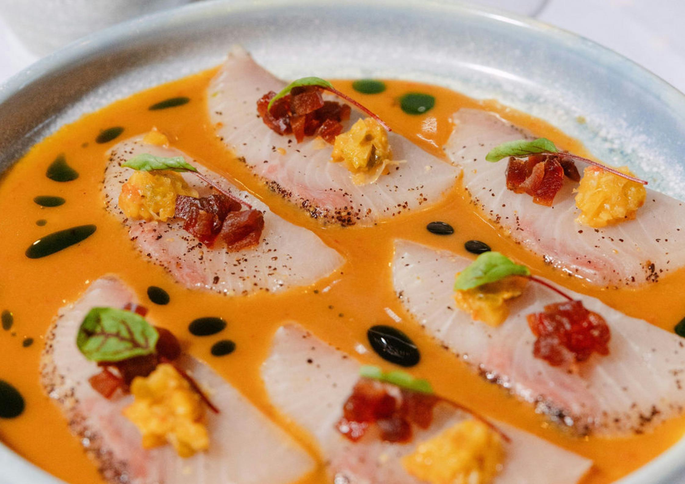 A photo of bright colourful kingfish orange sauce