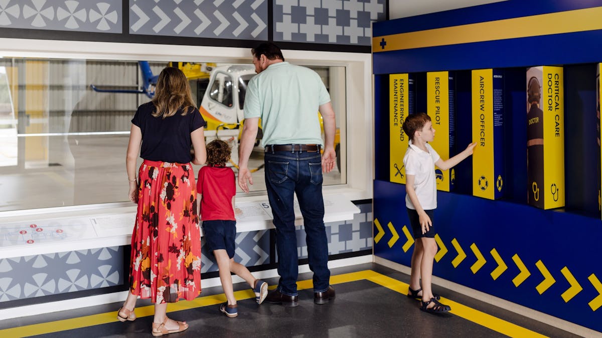 Parents with two children exploring the Centre with a helicopter in the hangar