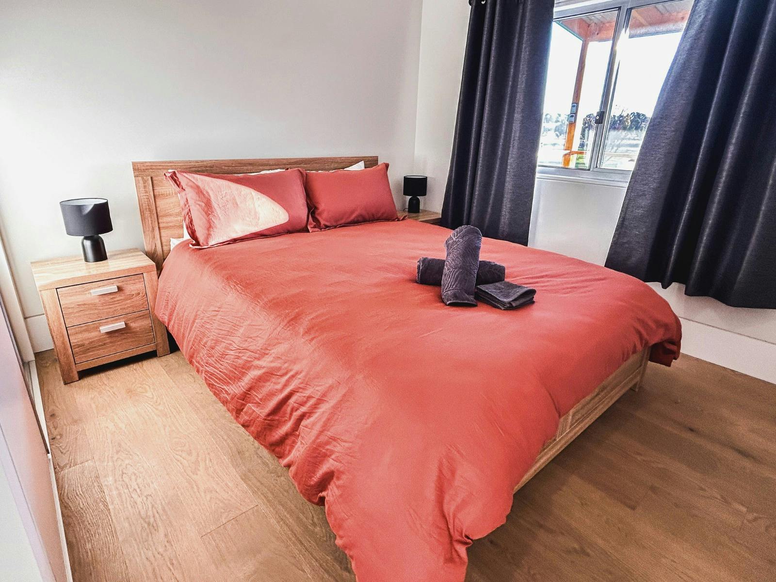 린넨과 침대 옆 탁자가 있는 퀸 사이즈 침대