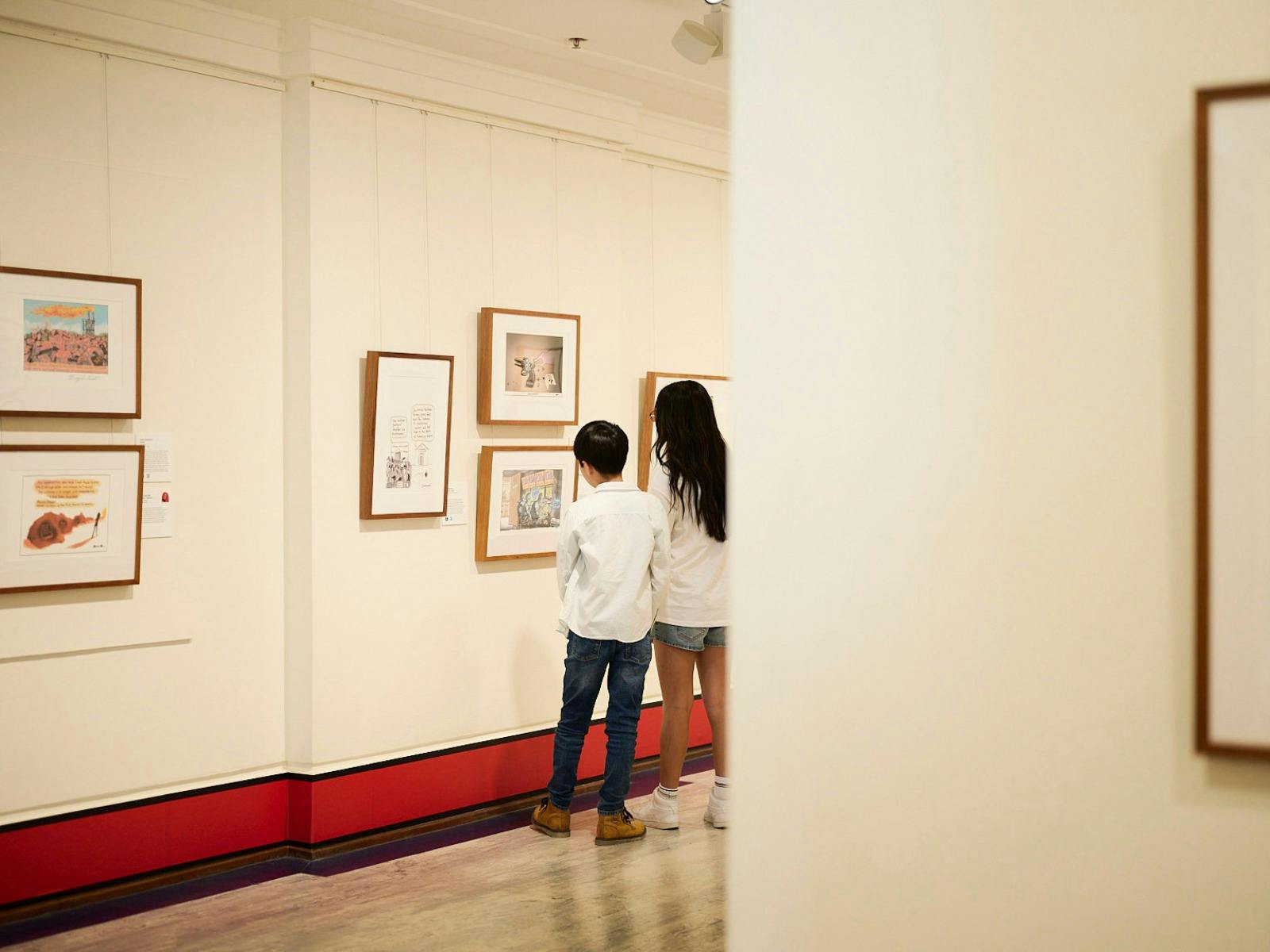 Children view artwork in gallery.