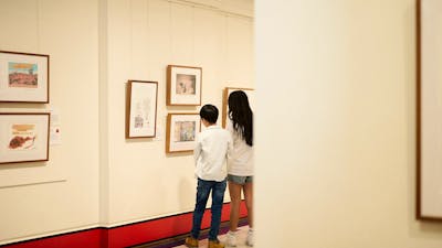 Children view artwork in gallery.