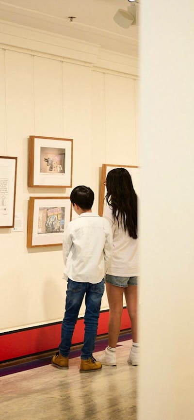 Children view artwork in gallery.