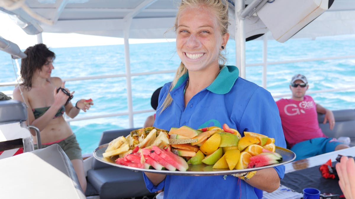 Serving fresh fruit platter on sail back from the Great Barrier Reef & Green Island on Ocean Free Serving fresh fruit platter on sail back from the Great Barrier Reef & Green Island on Ocean Free