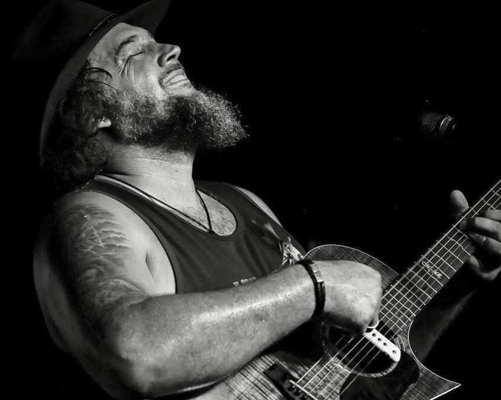 a man with his head back playing a guitar