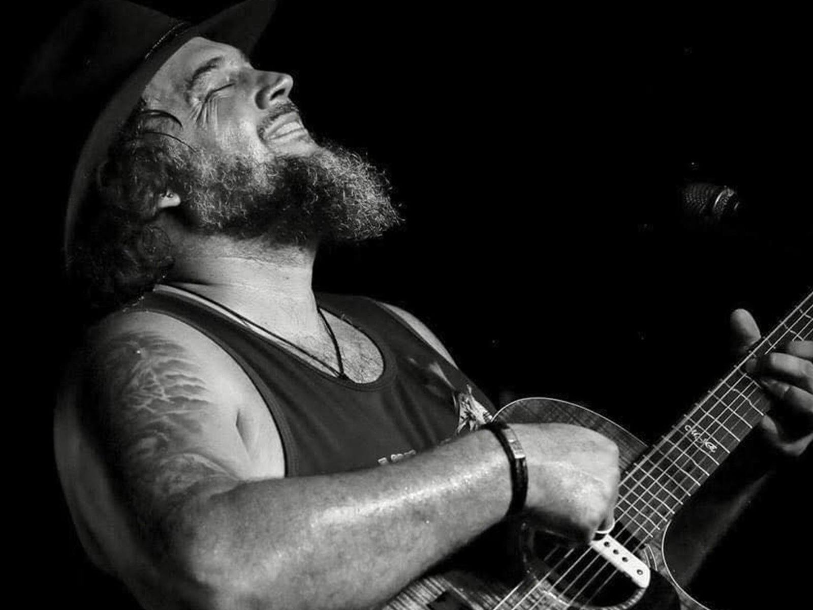 a man with his head back playing a guitar