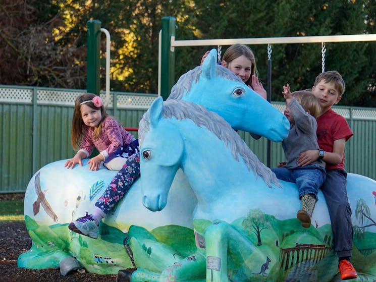 Kids on Painted Ponies in Playground