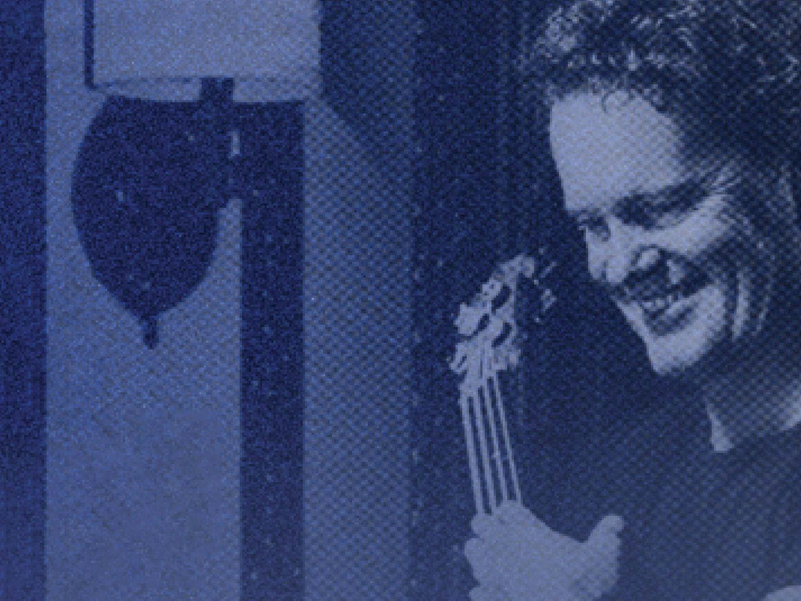 A grainy photo of Craig with his guitar