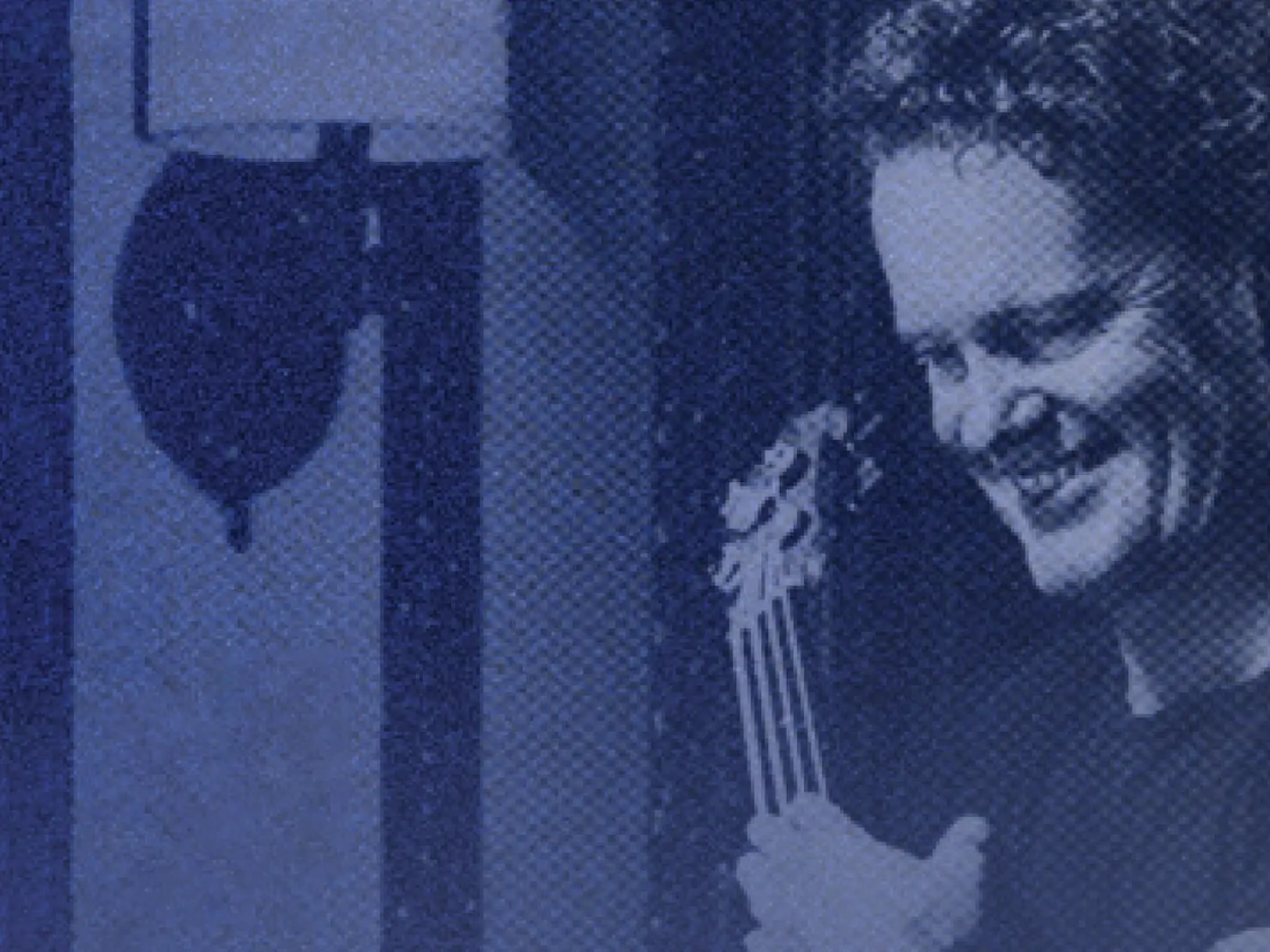 A grainy photo of Craig with his guitar