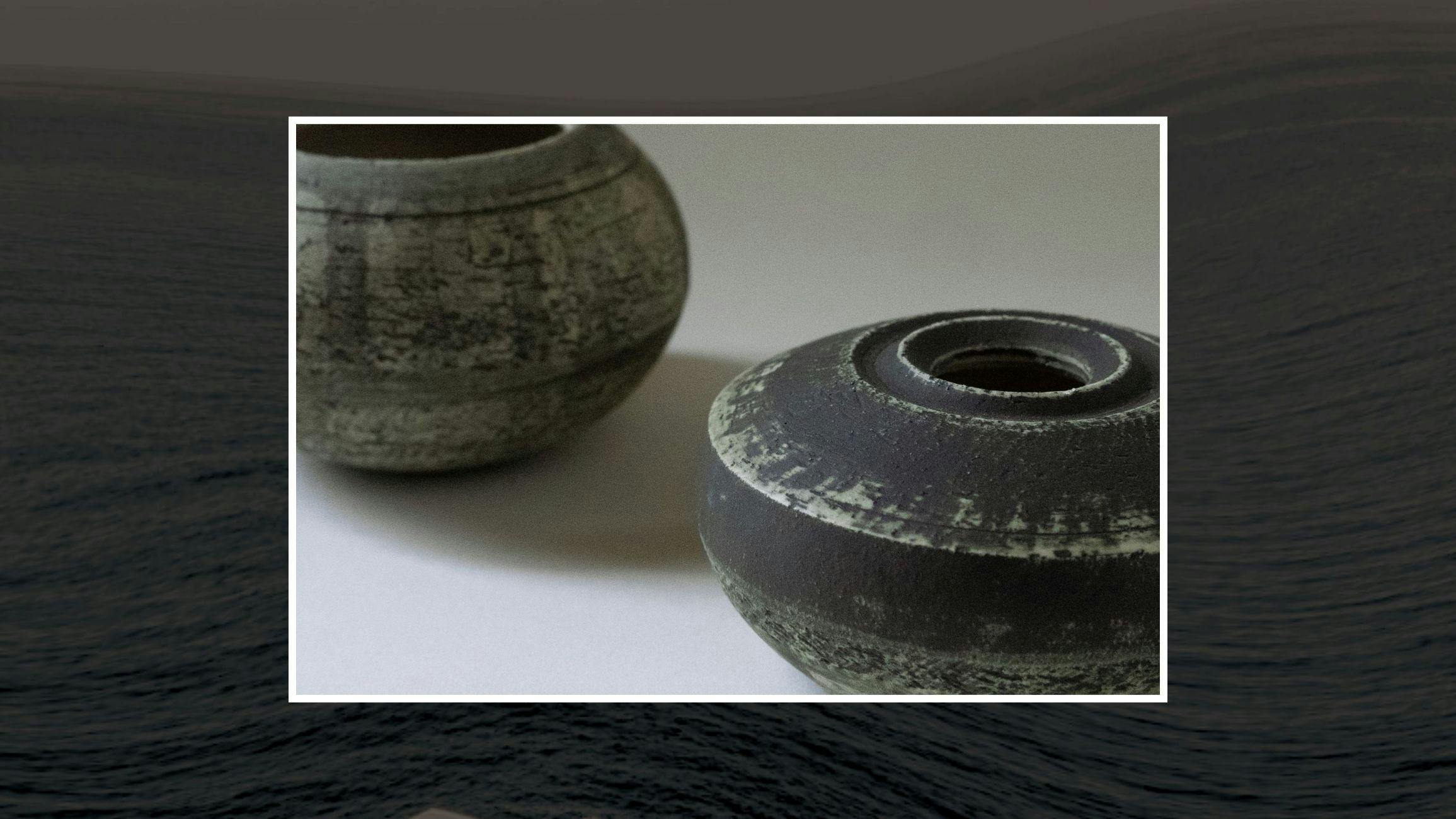 Two rustic ceramic vessels on table.