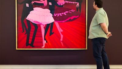 A person views a large painted portrait depicting people dancing, hanging on a gallery wall