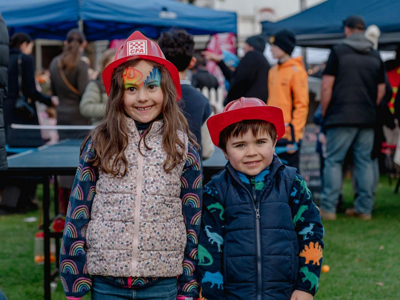 Two children wearing CFA hats, girl with face painted with fire and ice.