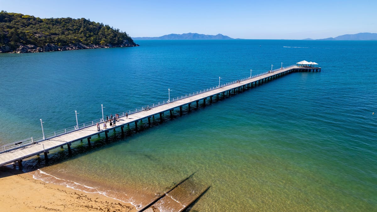 Drone shot of picnic bay jetty, beach in foreground jetty extending into distance