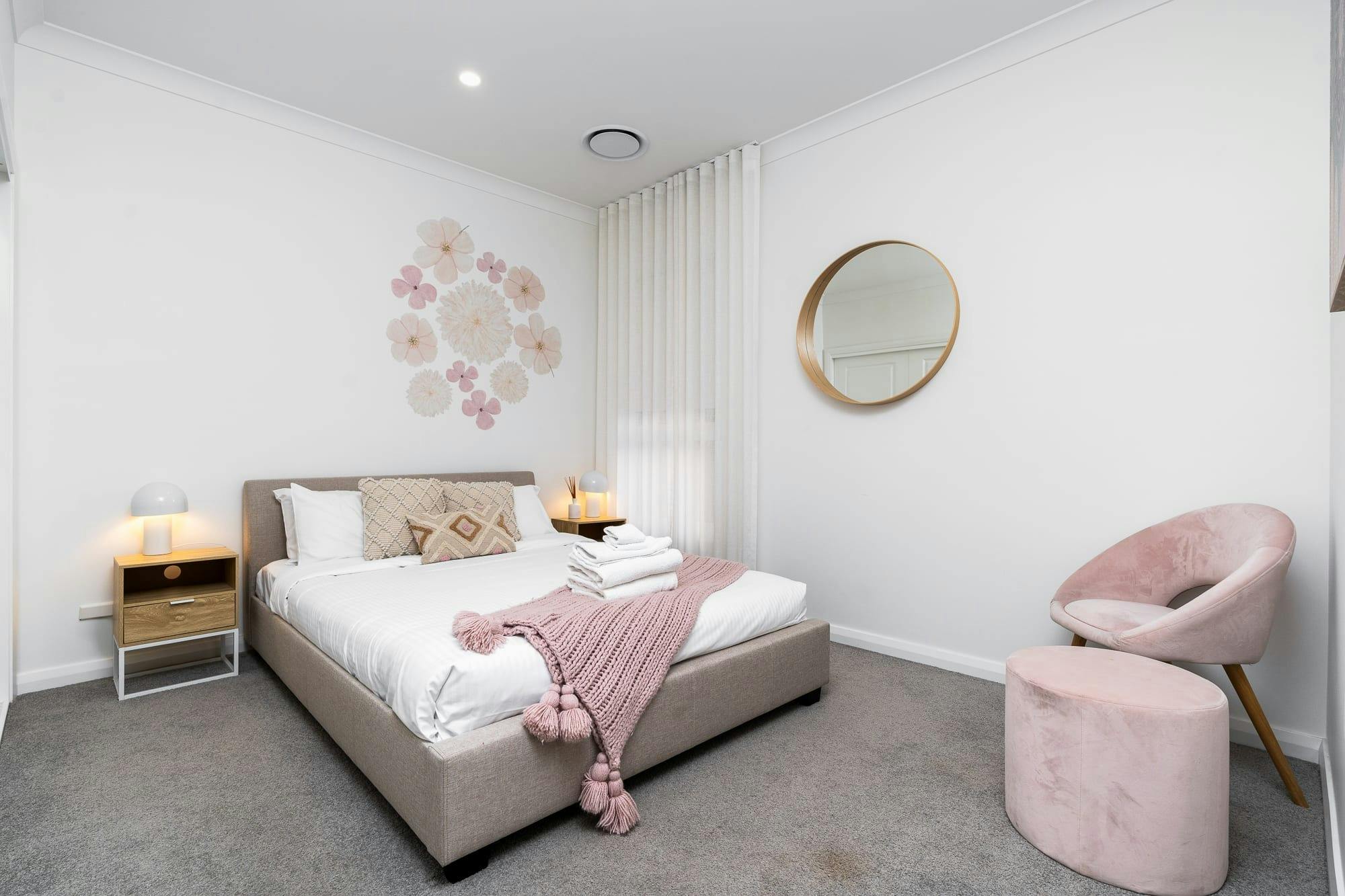 アームチェアと窓のある広いベッドルーム