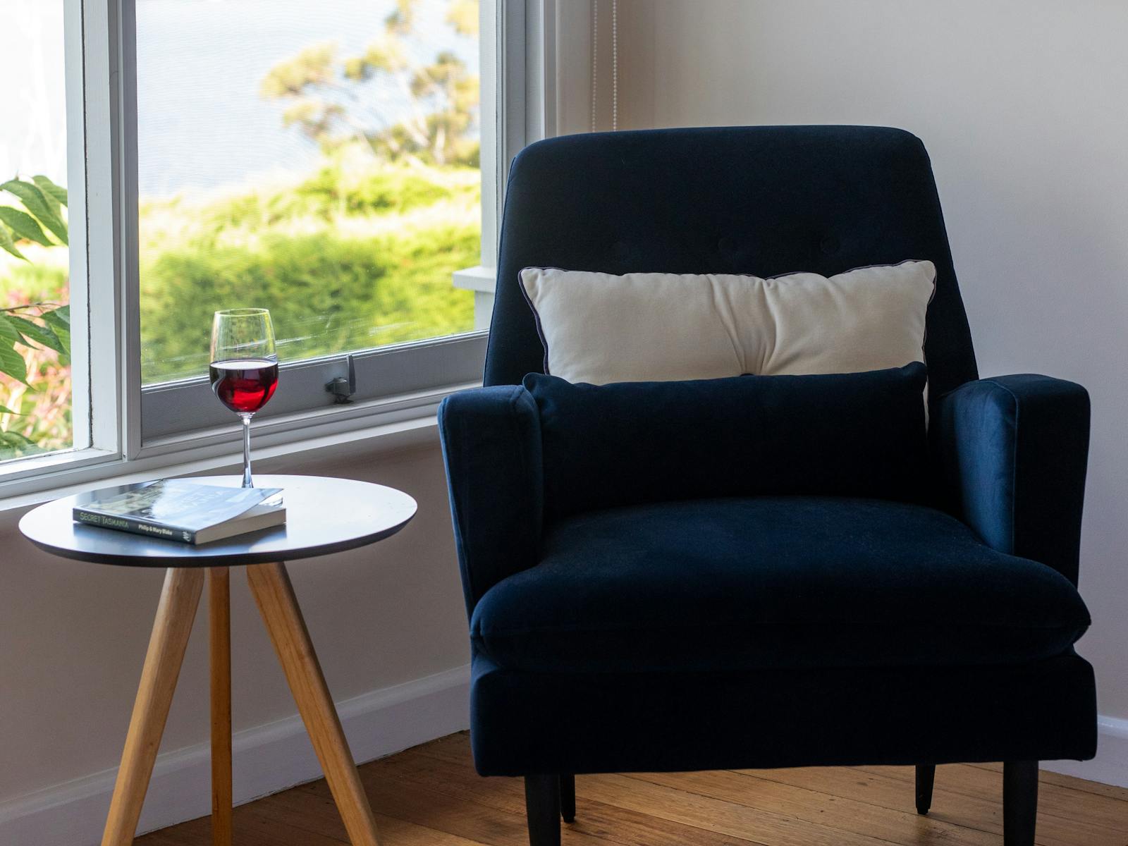 Image of a lounge chair with a glass of wine and a view in the background