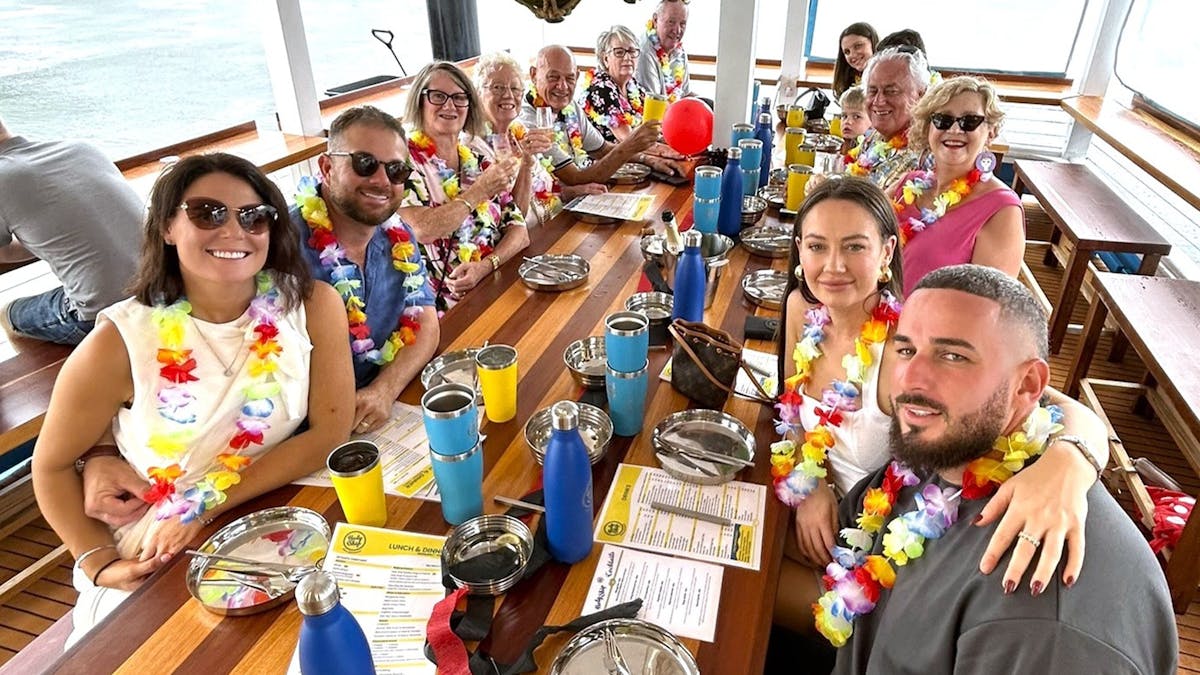 A group of people sitting on Holy Ships Lower deck smiling
