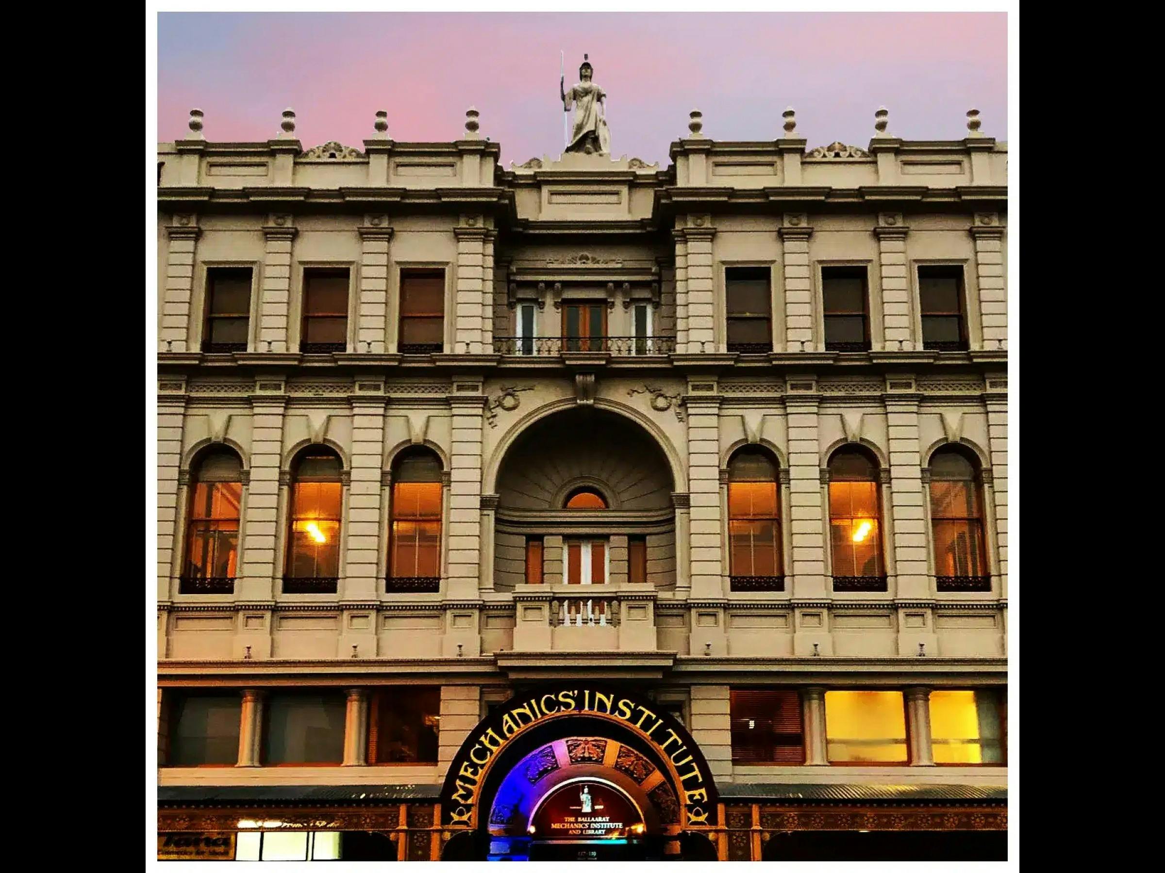 The historic façade of Ballarat Mechanics Institute in central Ballarat, lit warmly at dusk.
