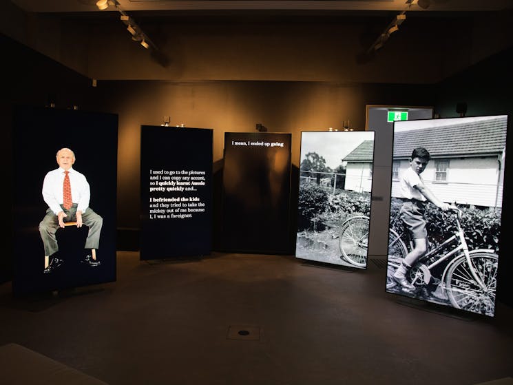 Photo of 5 screens playing Holocaust survivor testimonies