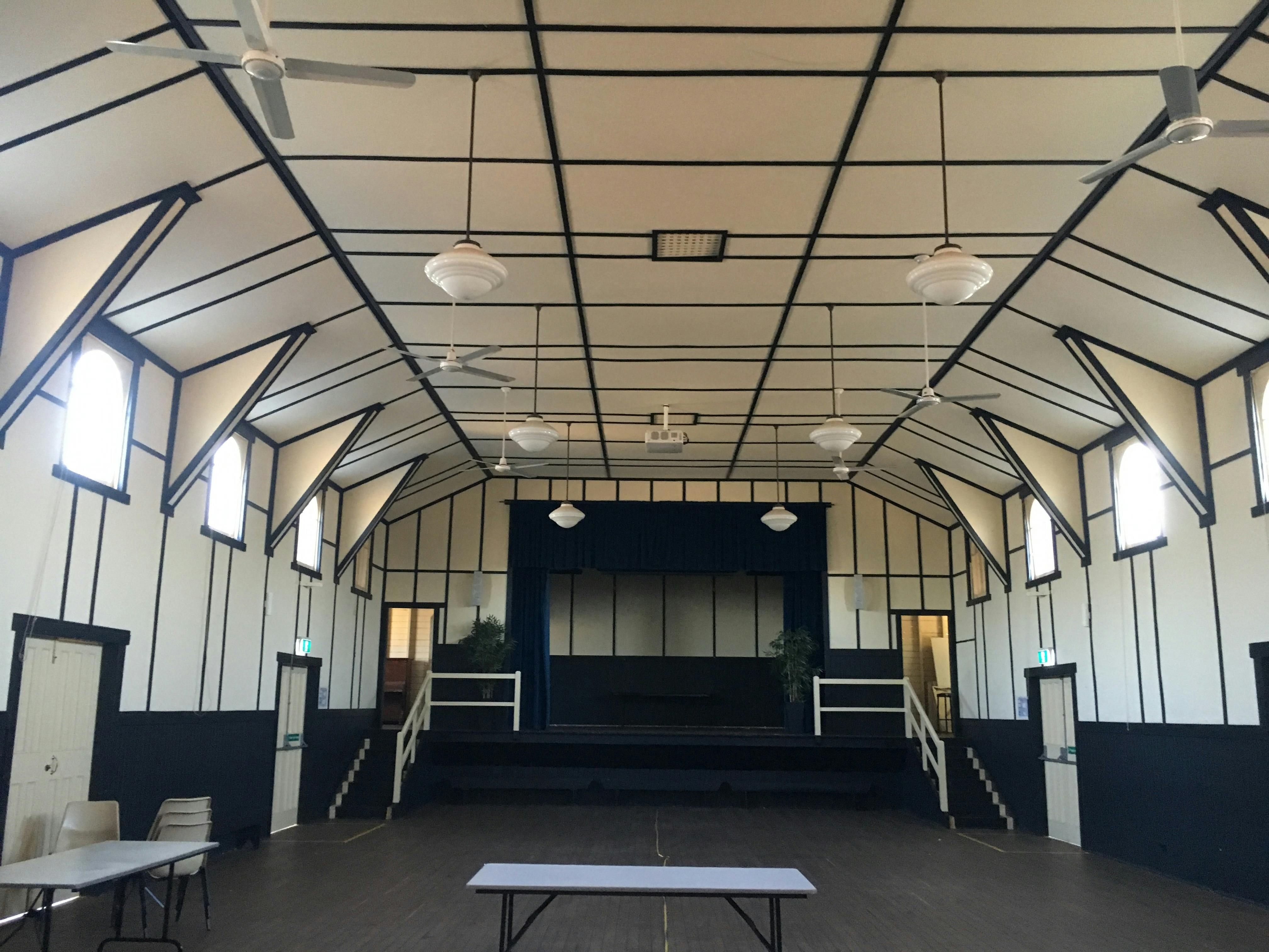 Interior of the Surat Shire Hall, with dark floorboards and high, white ceiling and black trim