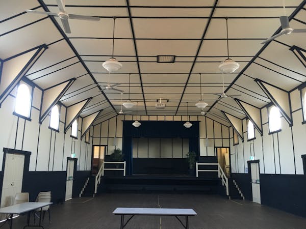 Interior of the Surat Shire Hall, with dark floorboards and high, white ceiling and black trim
