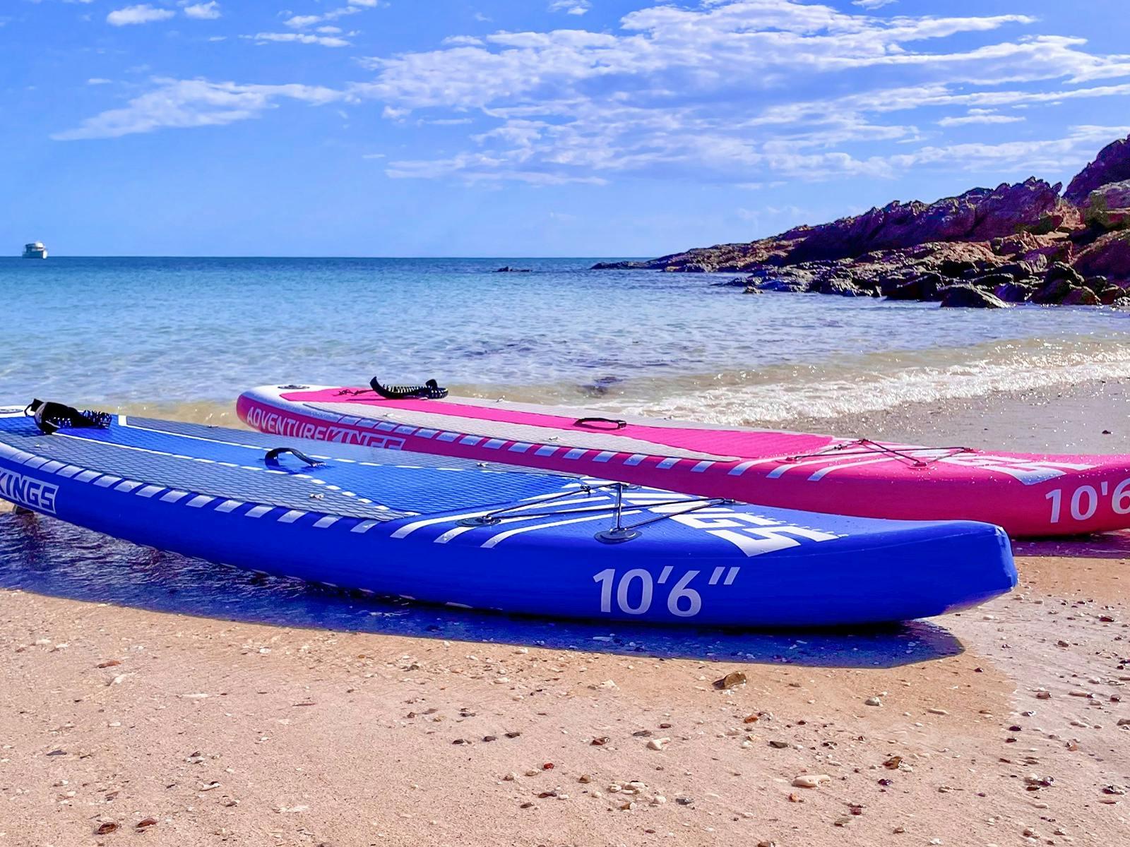 Image of blue and pink paddleboards on beautiful beach Image of blue and pink paddleboards on beautiful beach