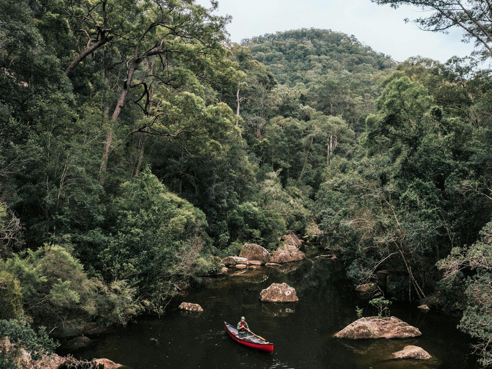 A red canoe in a wilderness creek