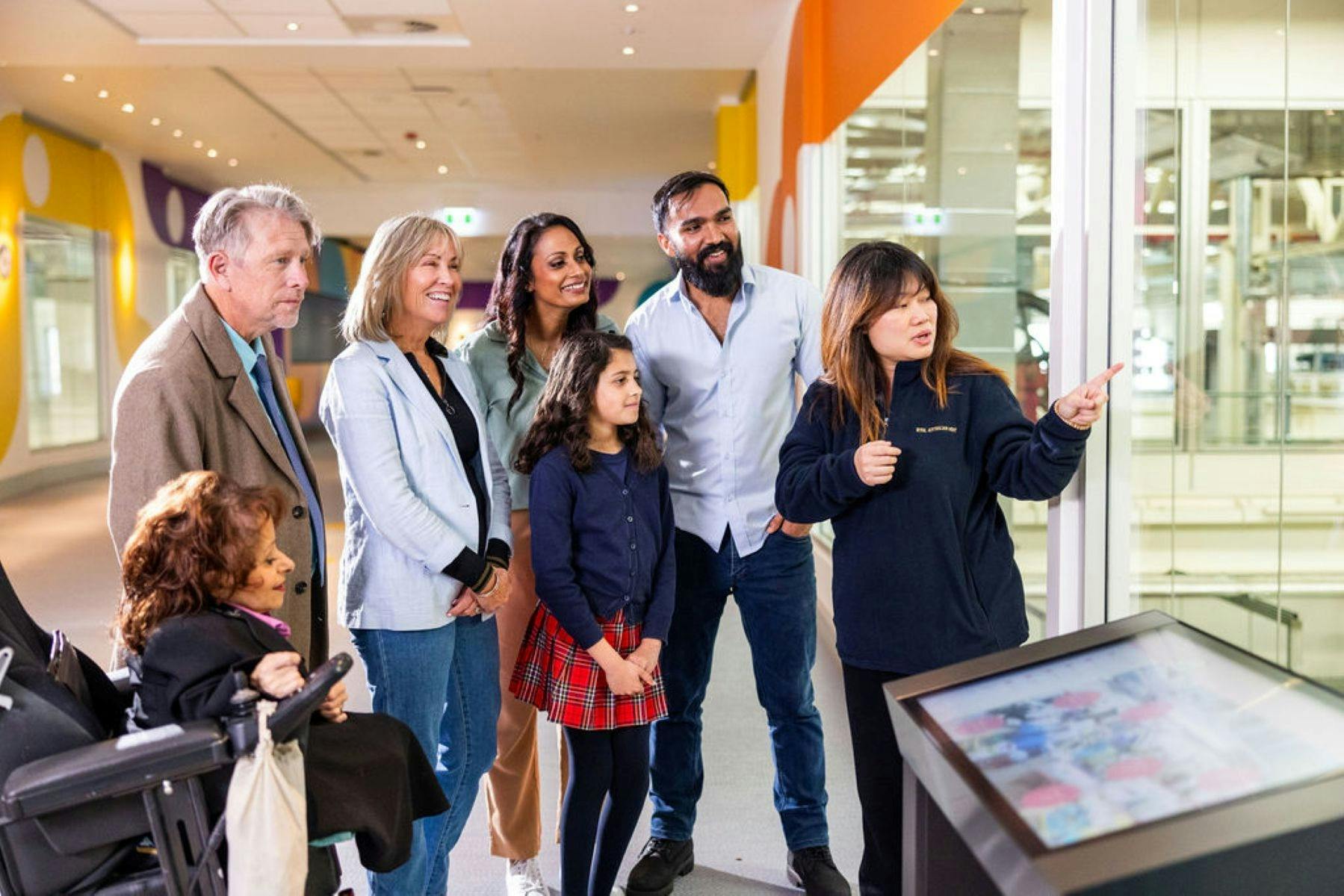 A group enjoying a free guided tour overlooking the working factory at the Mint