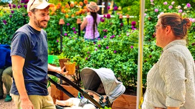 Man with baby talks to stallholder at Harvest Day Out