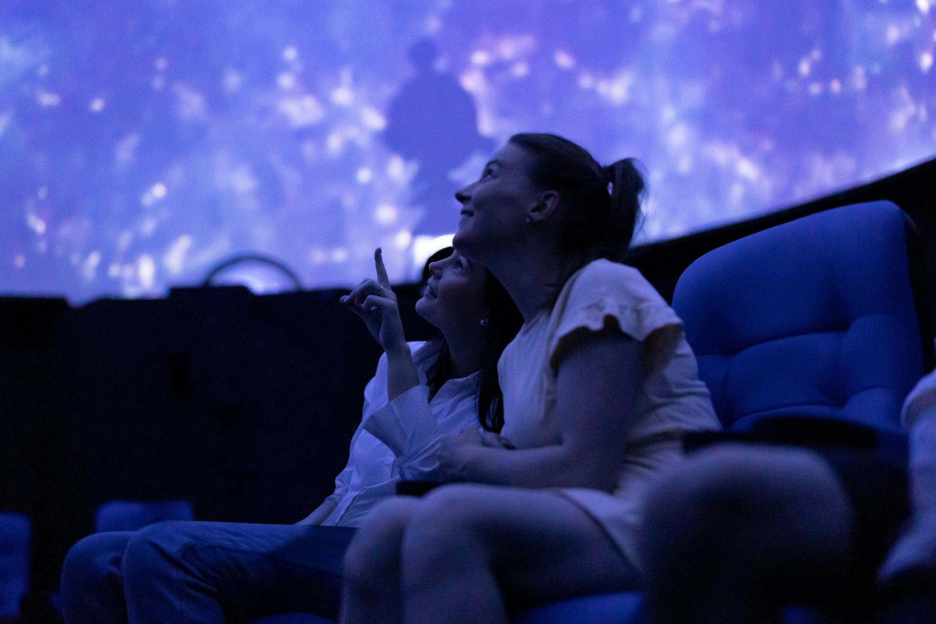 Two people look up at a full-dome screen.