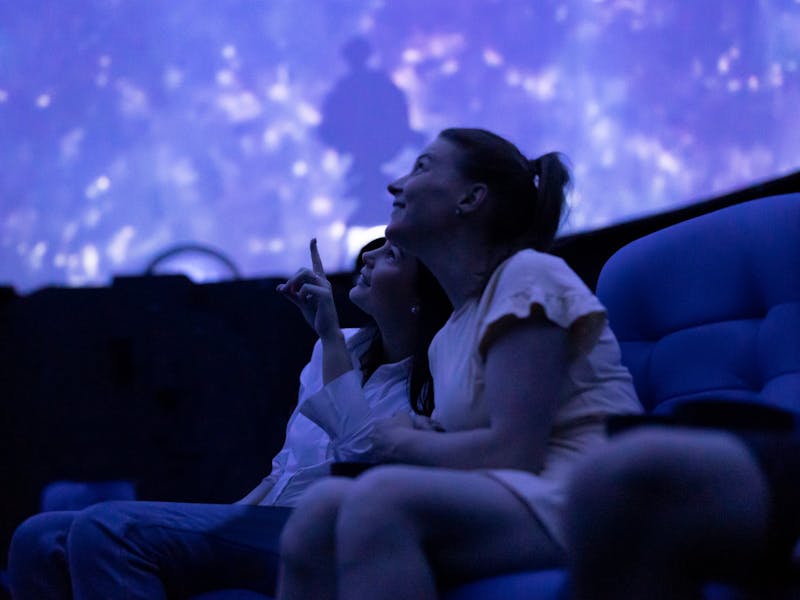 Two people look up at a full-dome screen.