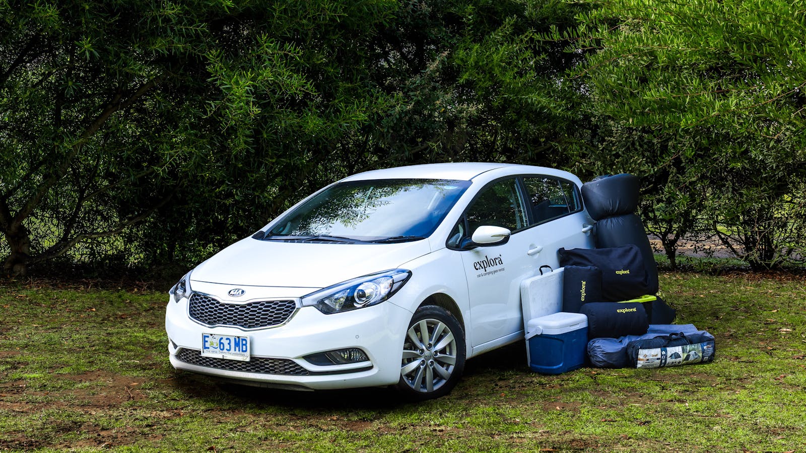 A Kia Cerato with the camping gear standing next to it