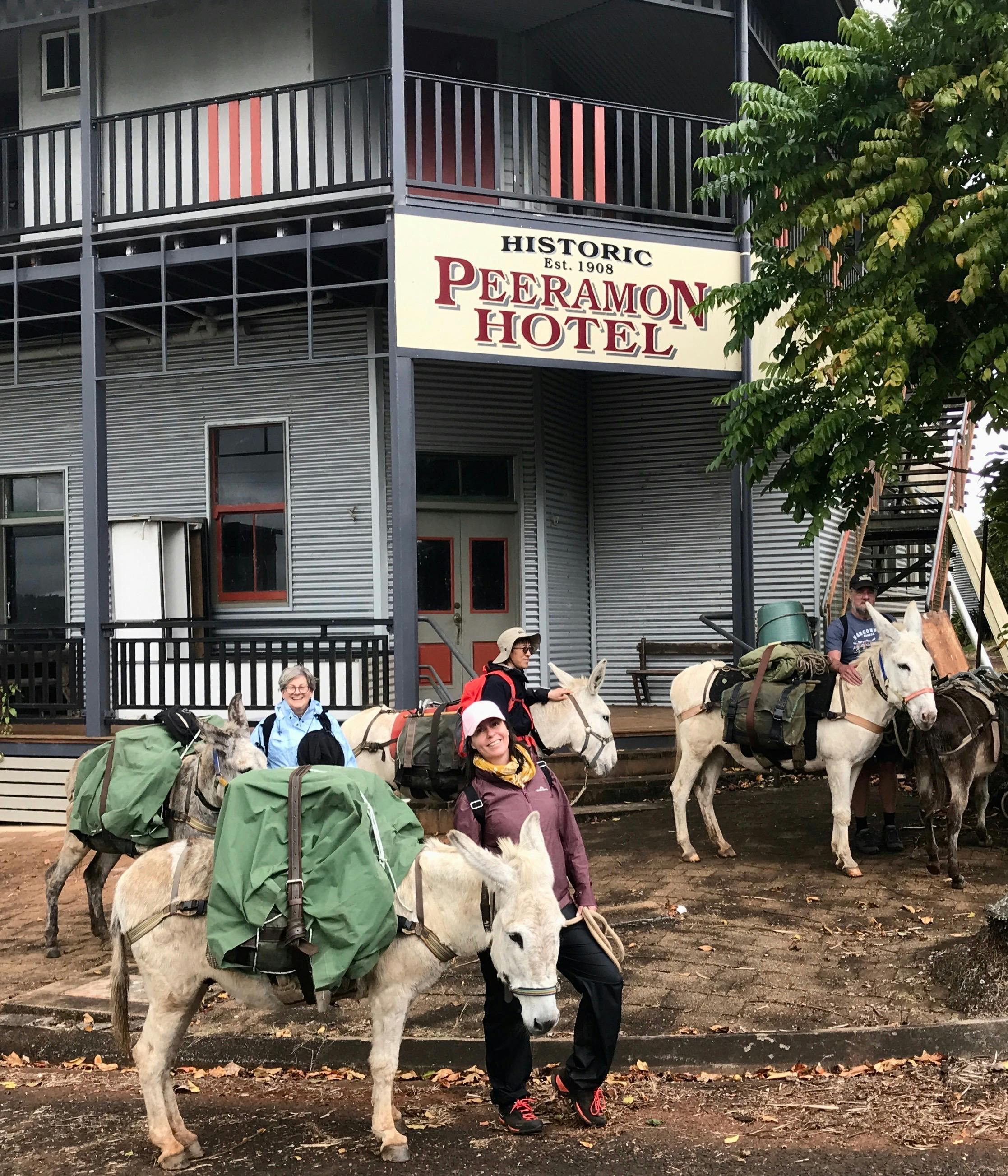 A group of four trekkers pose with pack donkeys, outside the Classic Queensland Peeramon Pub.