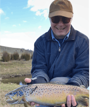 Client holding a large brown trout at 28 Gates before it is released