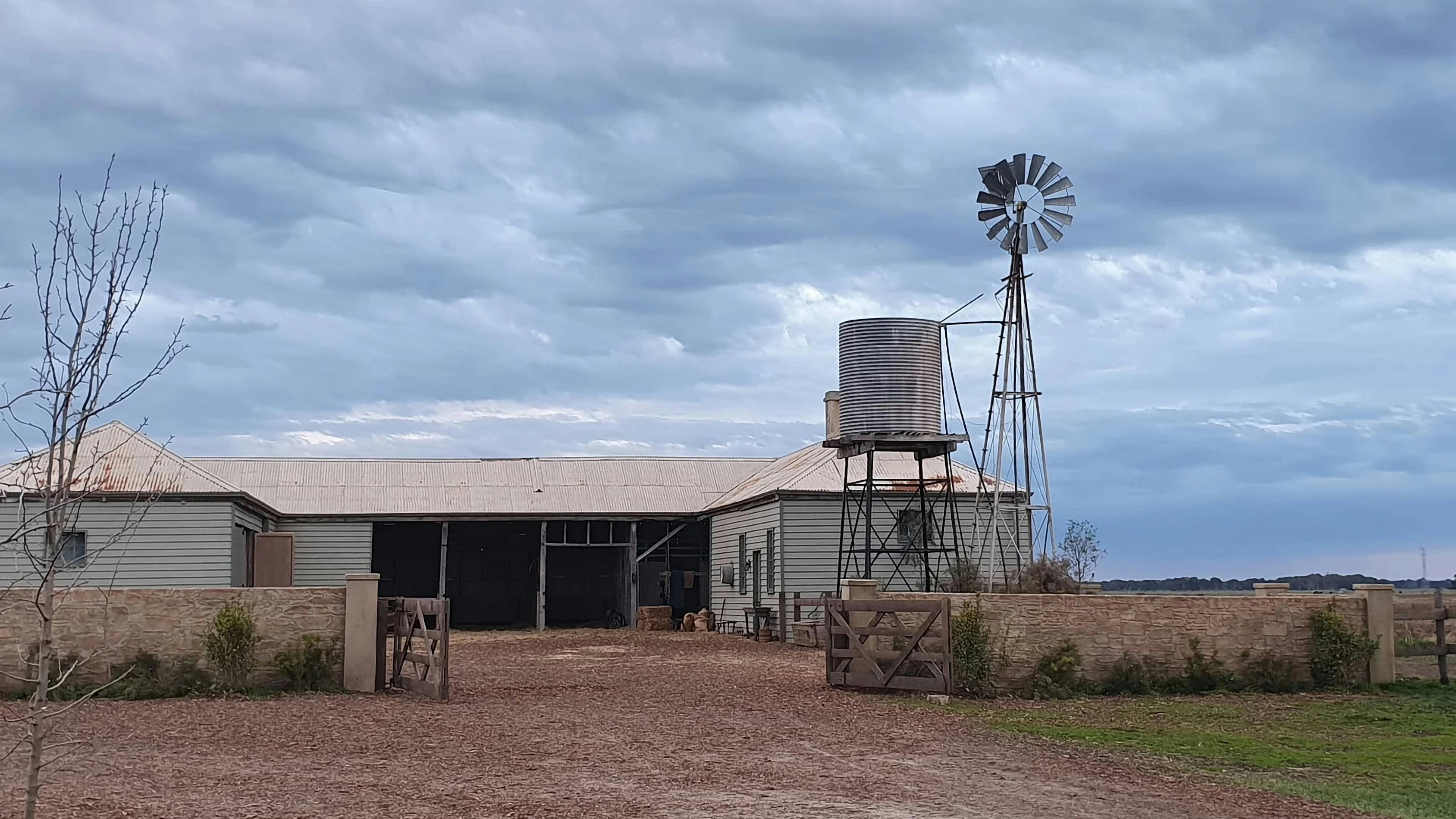 Historic barn, windmill and water tank on the Yallum Park property at dusk