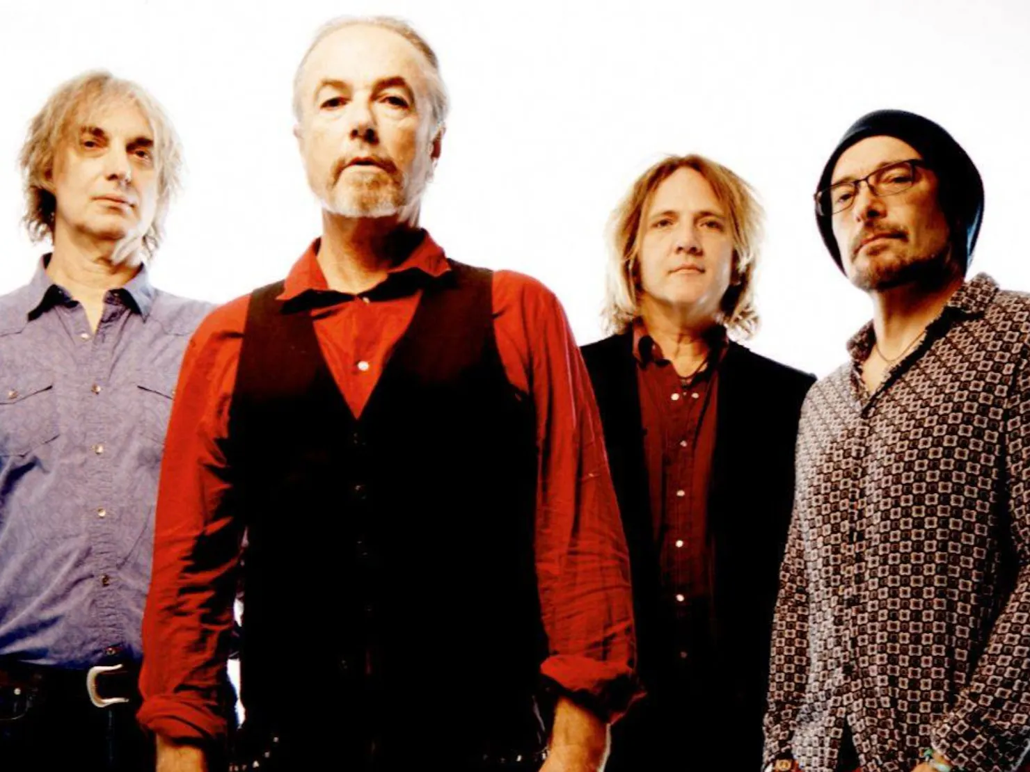 All 5 band members standing in black clothes in a dim Smokey light