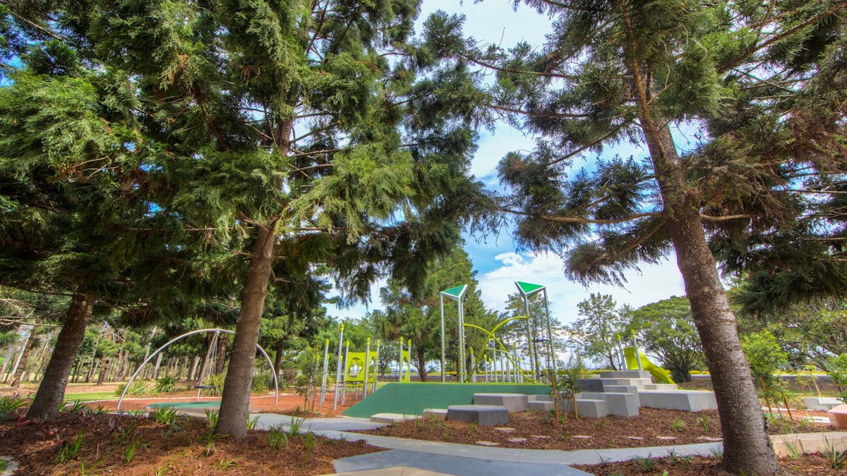 Shaded play area under large trees at Pine Rivers Park