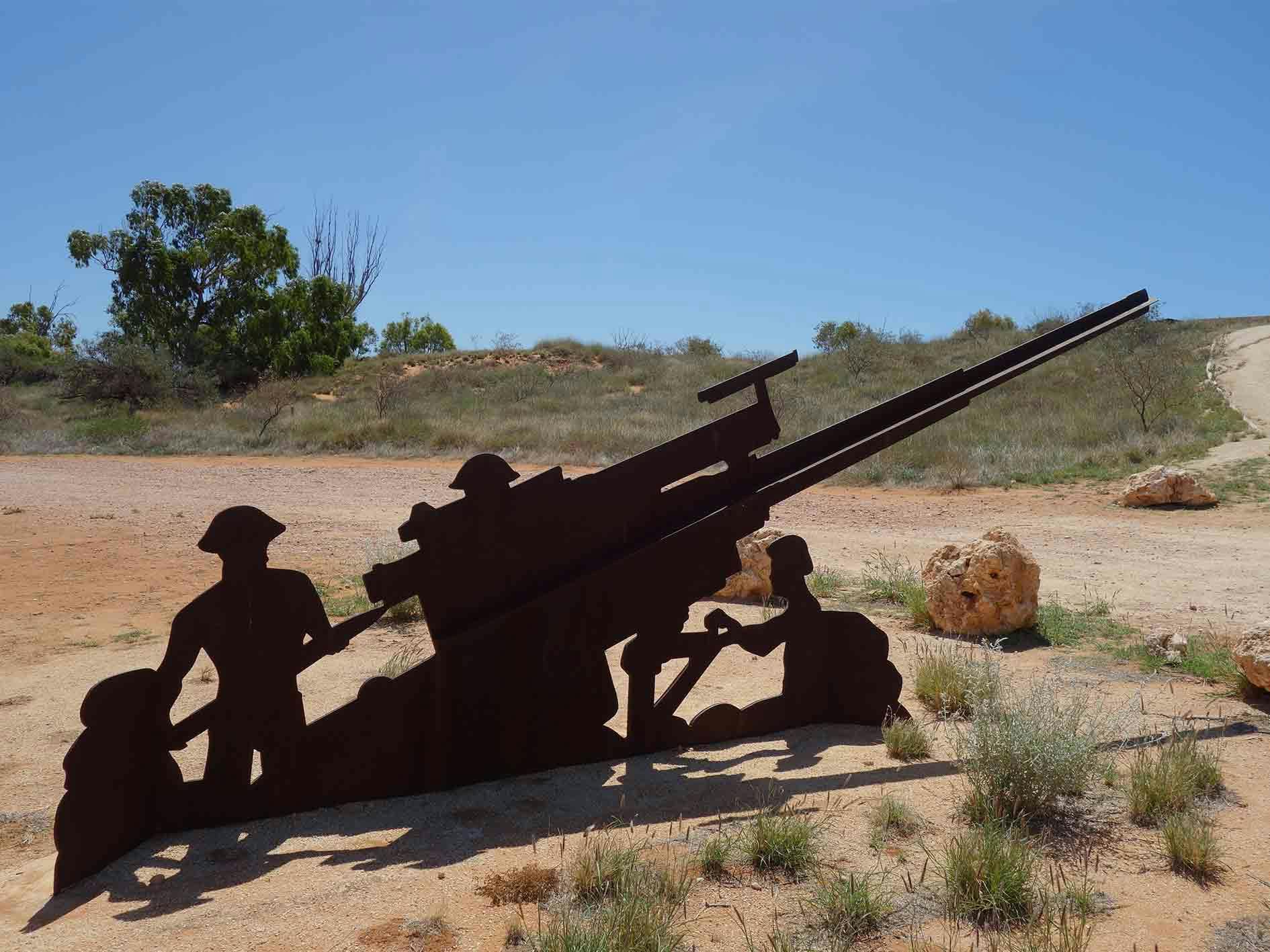 A cutout sculpture of troops and a tank near the Potshot Memorial
